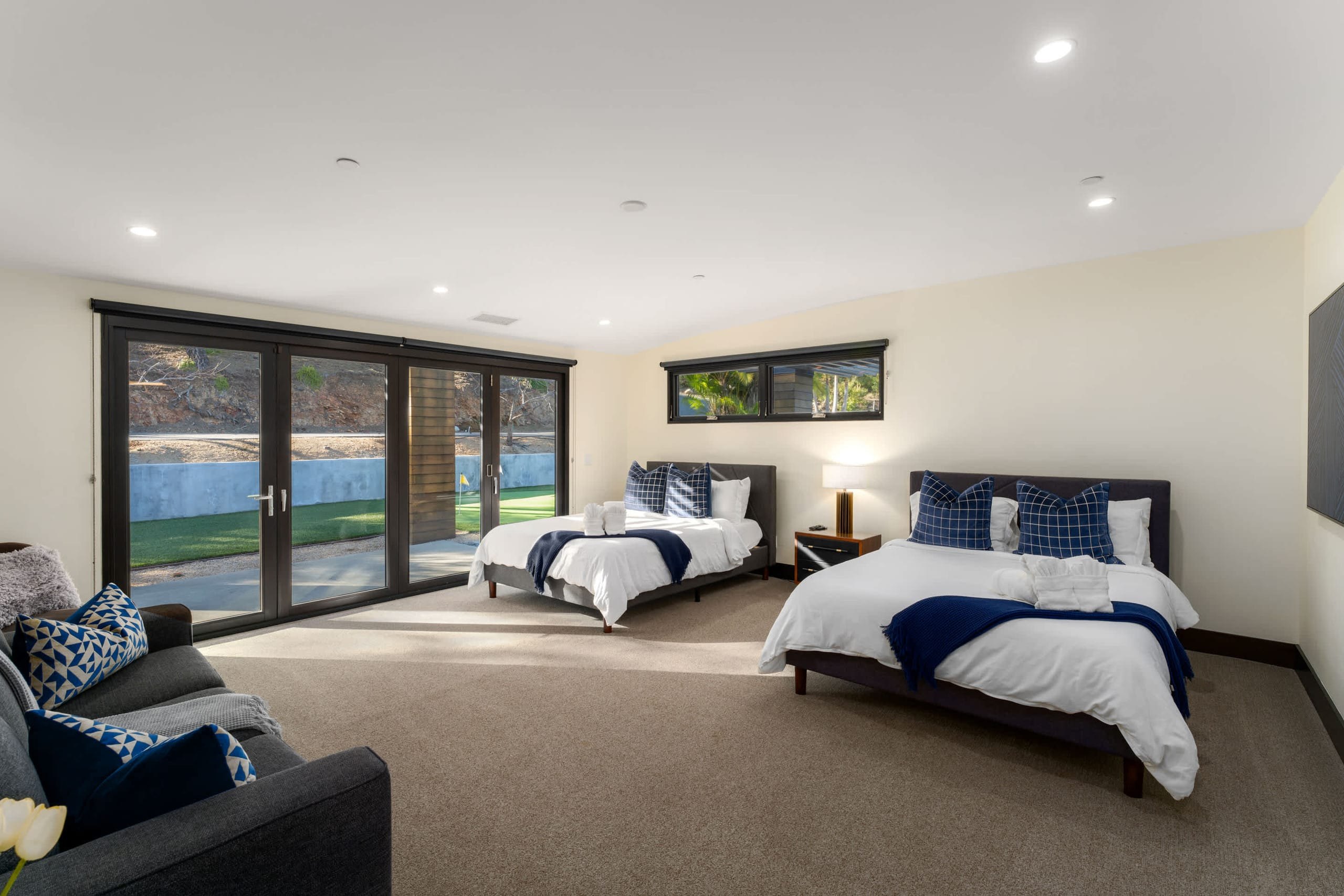 Light bedroom with two beds and glass doors to the garden